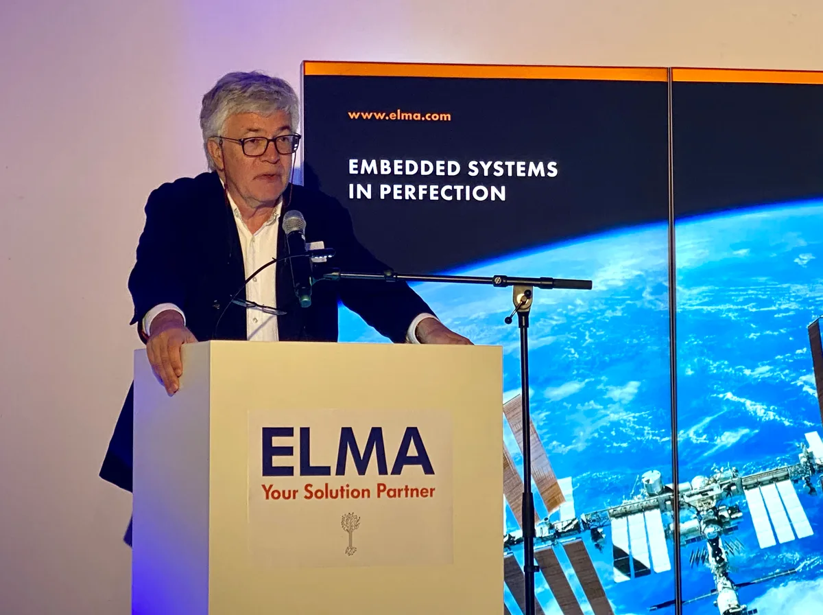 Ein Mann steht hinter einem Rednerpult, das mit «Elma» beschriftet ist.